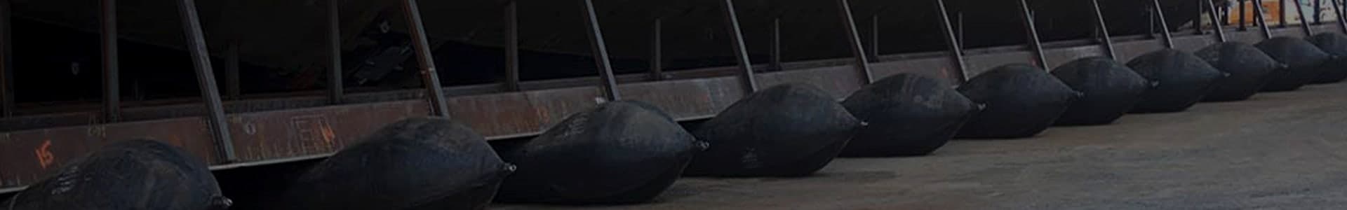 Row of marine rubber ship launching airbags under a hull on the slipway